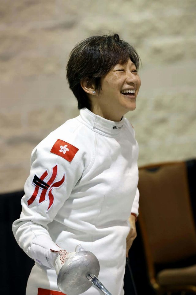 Ida Choy in her fencing jacket, laughing, epee in hand